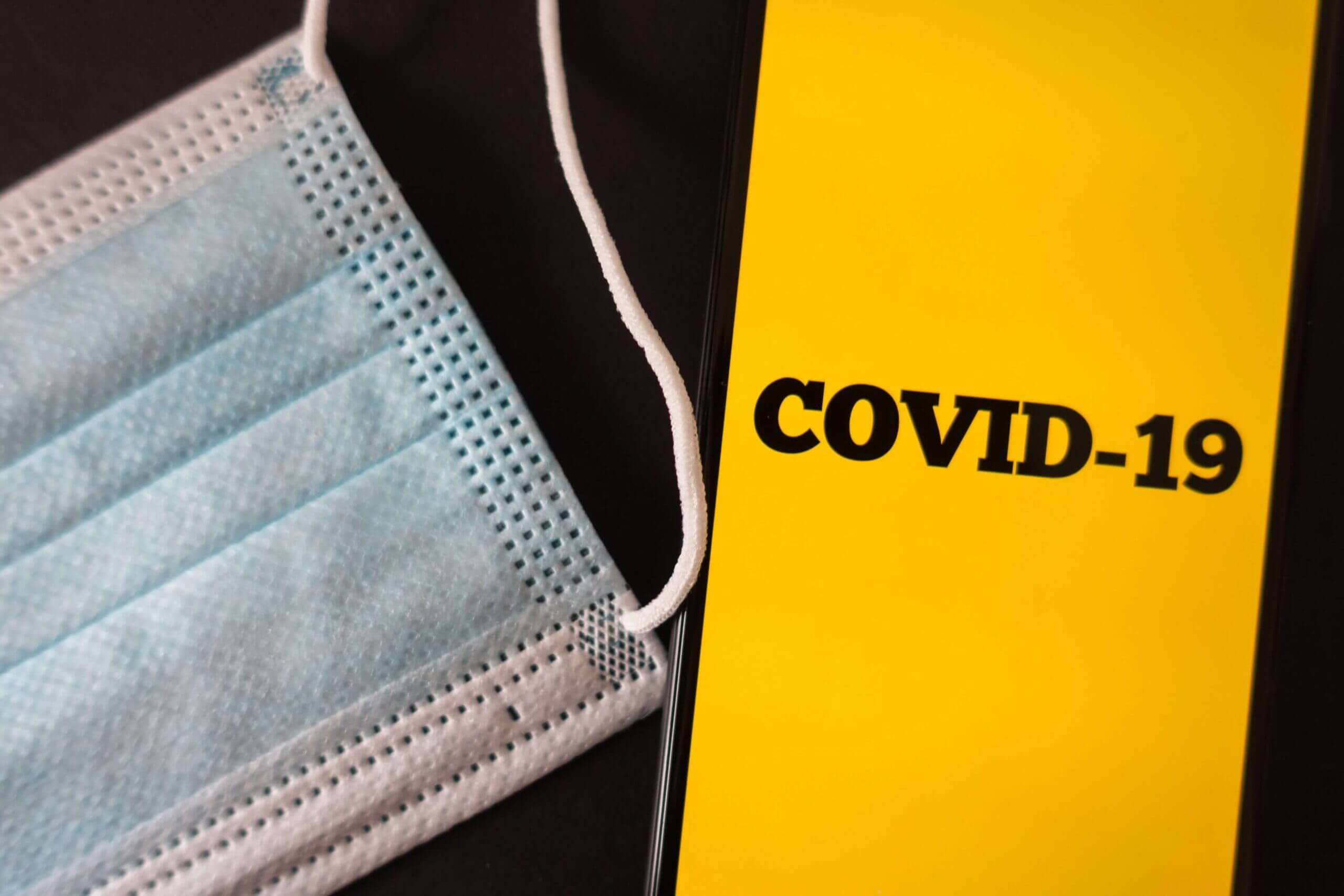 a mask and phone with the text "covid-19"